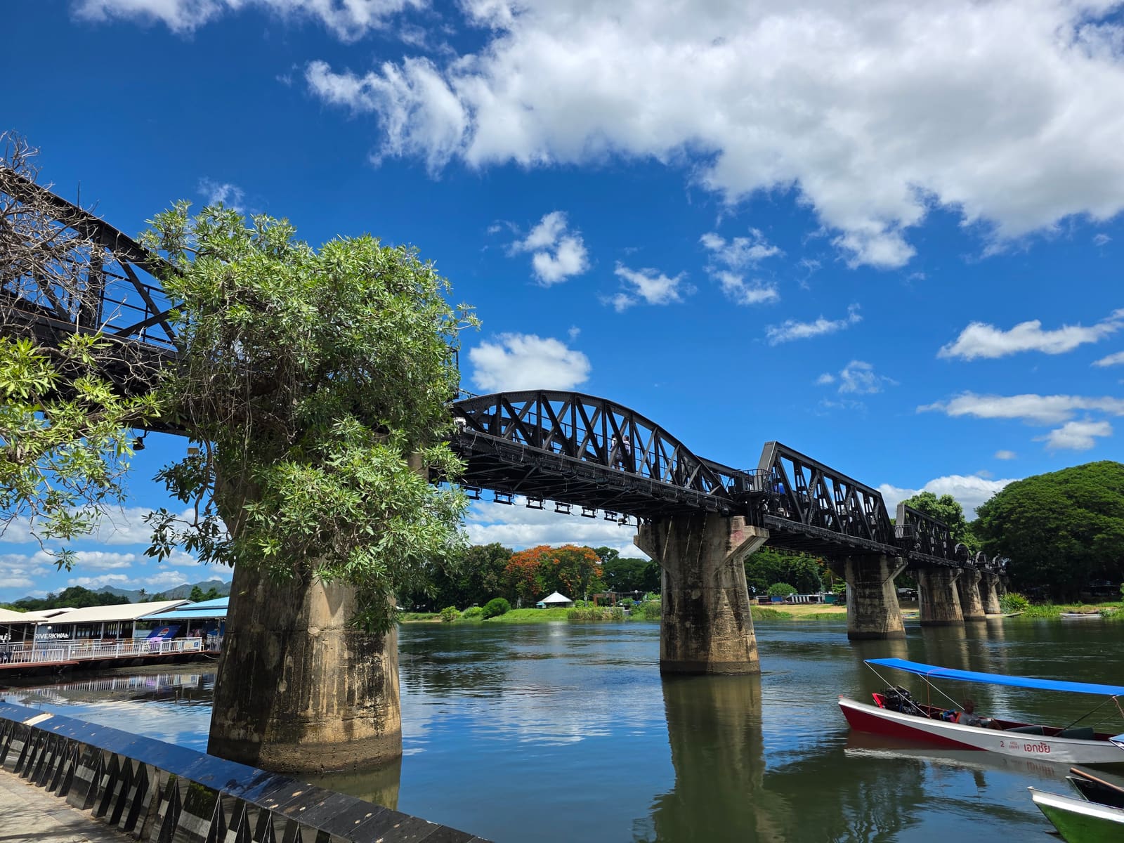 สะพานเป็นเงาตัดท้องฟ้า — สะพานข้ามแม่น้ำแคว River Kwai Bridge กาญจนบุรี ประเทศไทย